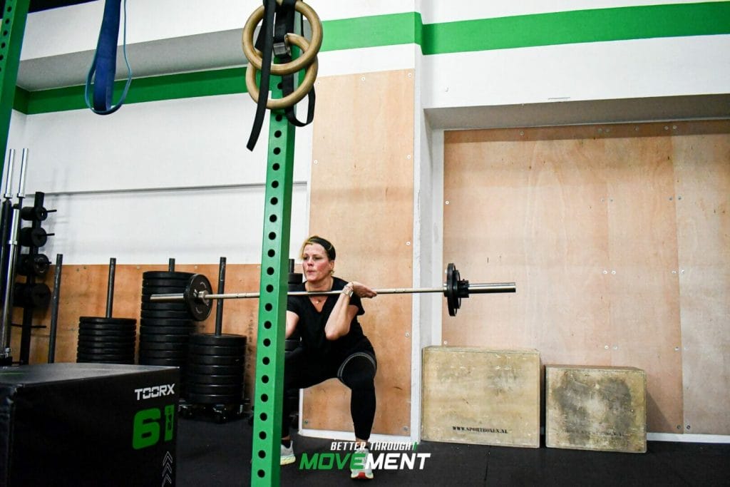 Vrouw maakt front squats tijdens CrossFit training in fitness sportschool Zevenbergen