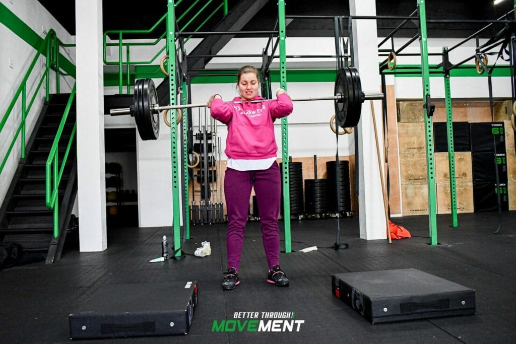 Vrouw aan het gewichtheffen met barbell tijdens CrossFit training in Sportschool Zevenbergen