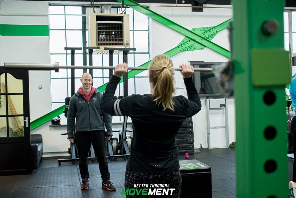 Vrouw werkt met coach tijdens CrossFit training in sportschool Zevenbergen