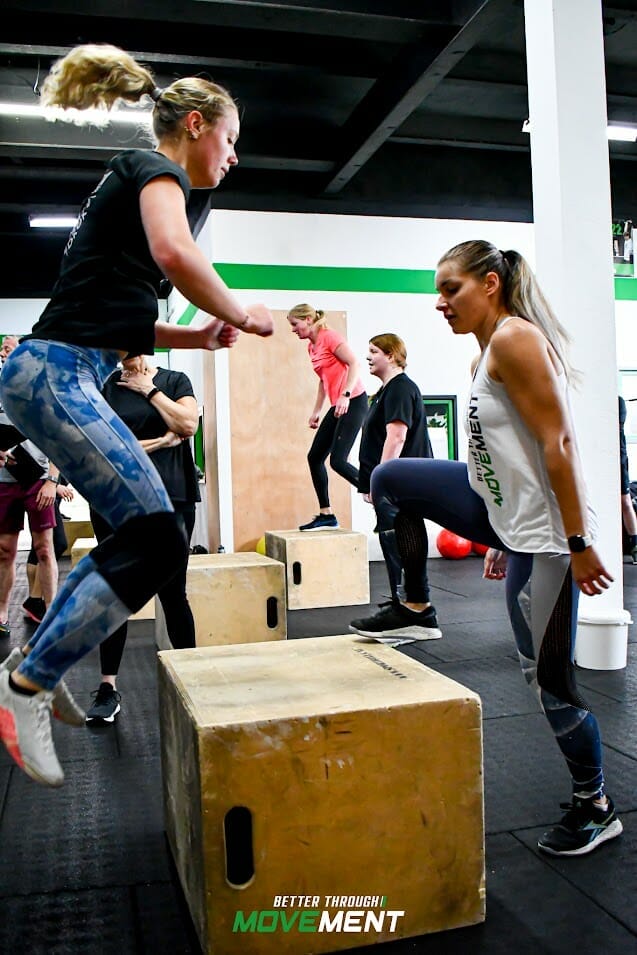 Dames springen samen op een box tijdens CrossFit sportles in sportschool Zevenbergen