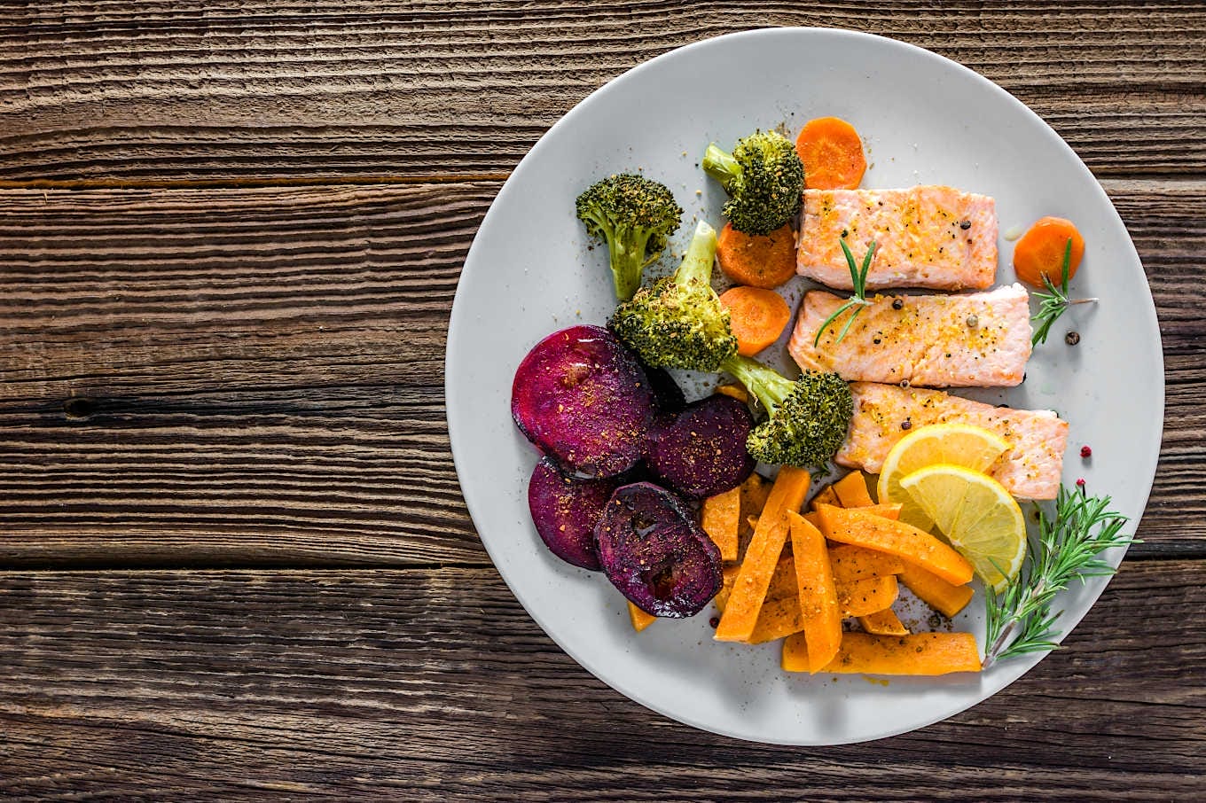 Bord met gezond eten van zalm, bieten, zoete aardappel en broccoli